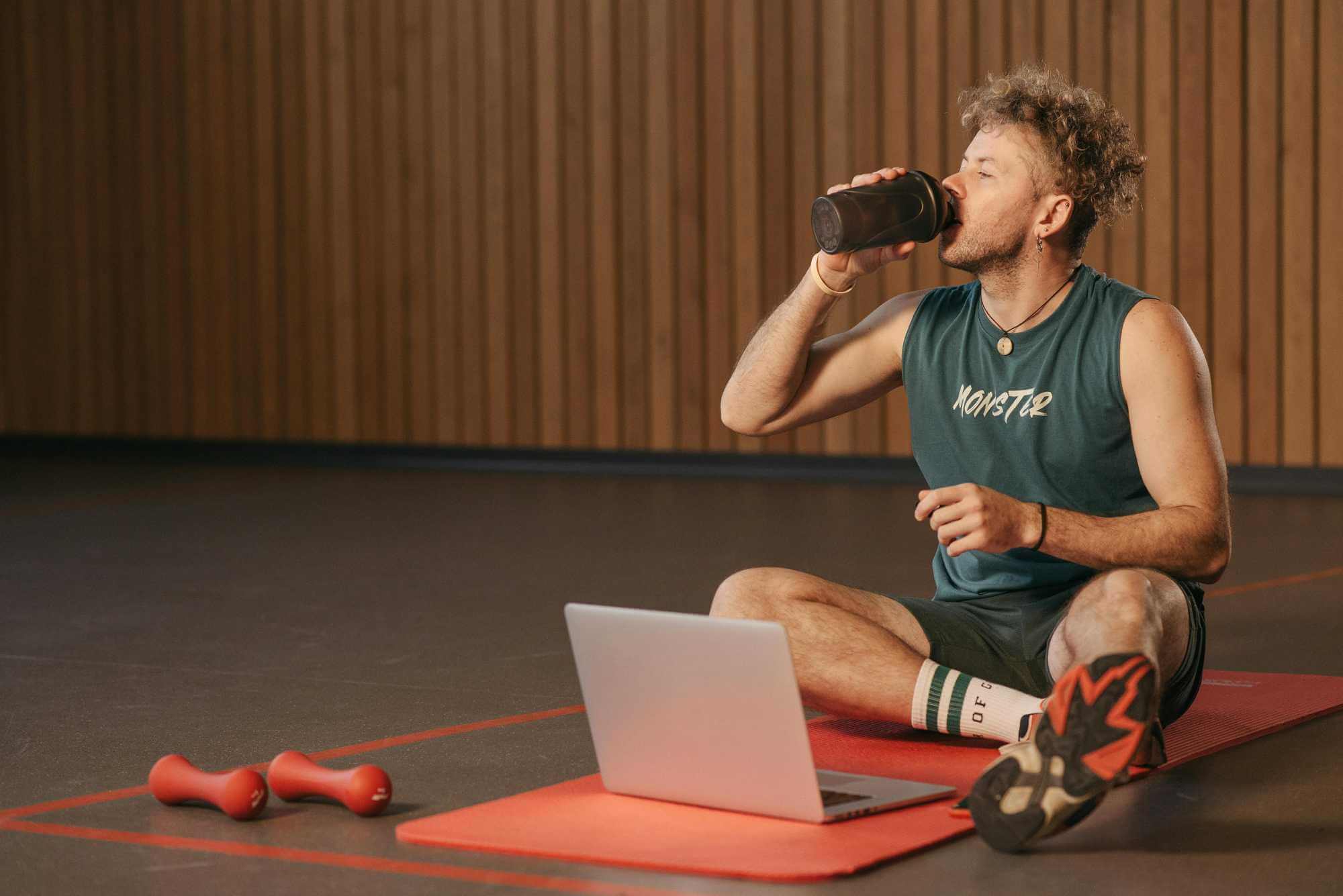 muž pije protein po fitku
